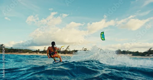 Beautiful young woman kiteboarding at sunset in slow motion, active lifestyle extreme sport
