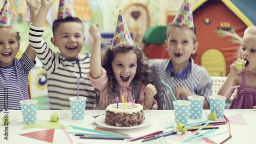 children blowing out candles on birthday cake
