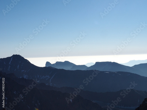 Mountains and Hills panoramic View with many stacked foggy smoky ranges highlighted back light Sunshine