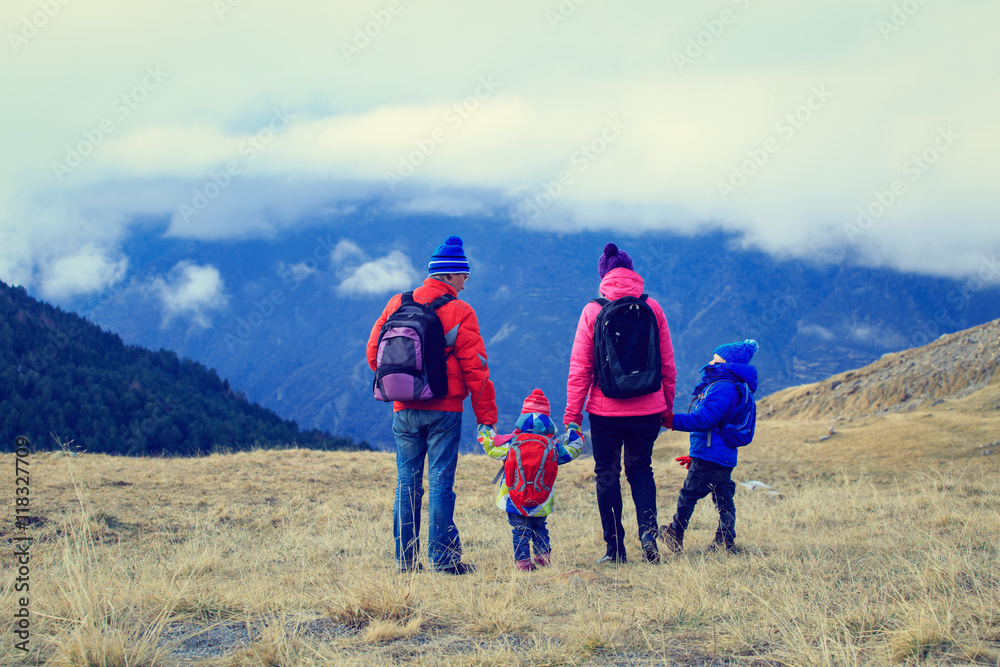 family with two kids hiking in winter mountains