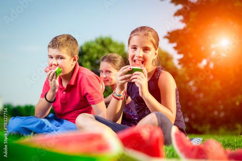 Cute children eating watermelon on a sunny day