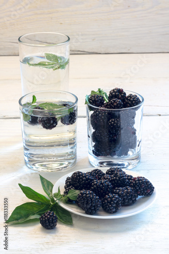 blackberry berries on a white plate with wood background
