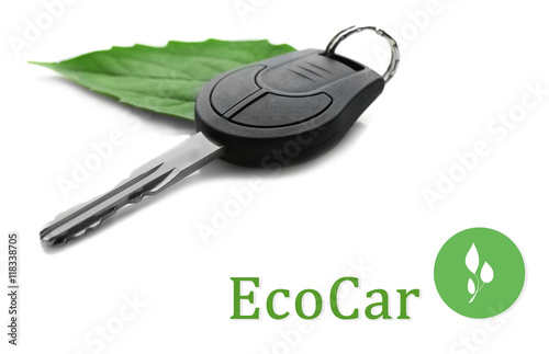 Car key with green leaf trinket and text ecocar on white background. Eco transport concept. photo