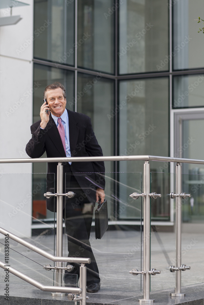 Caucasian businessman on cell phone outside building Caucasian businessman on cell phone outside building