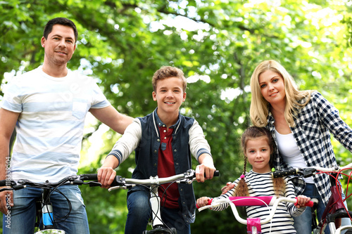 Happy family with bikes in park © Africa Studio