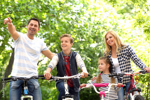 Happy family with bikes in park © Africa Studio