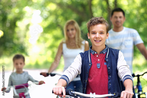 Cute boy with family on bike ride in park
