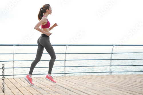 Young woman running on pier