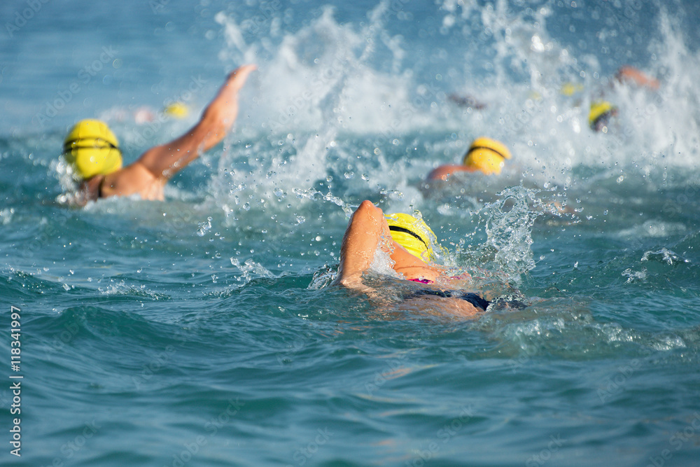 Group of swimmers swim in the blue sea at the races