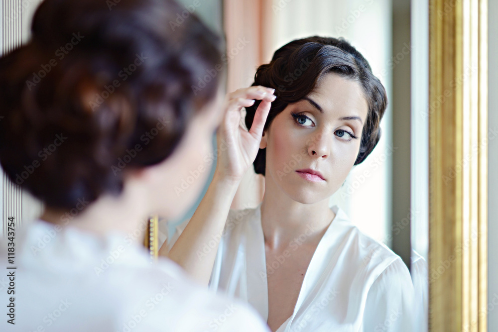 Fototapeta premium Beauty bride in dressing gown with bridal makeup indoors. Beautiful model girl in colorful wedding robe. Female portrait of cute lady. Woman with hairstyle