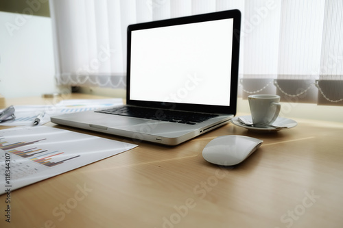 Laptop computer with blank white screen ready for content on wooden desk in meeting with business people discussing the charts and graphs background, selective focus. Business concept.