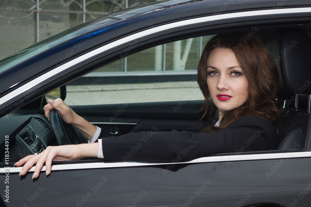 Young confident businesswoman driving car