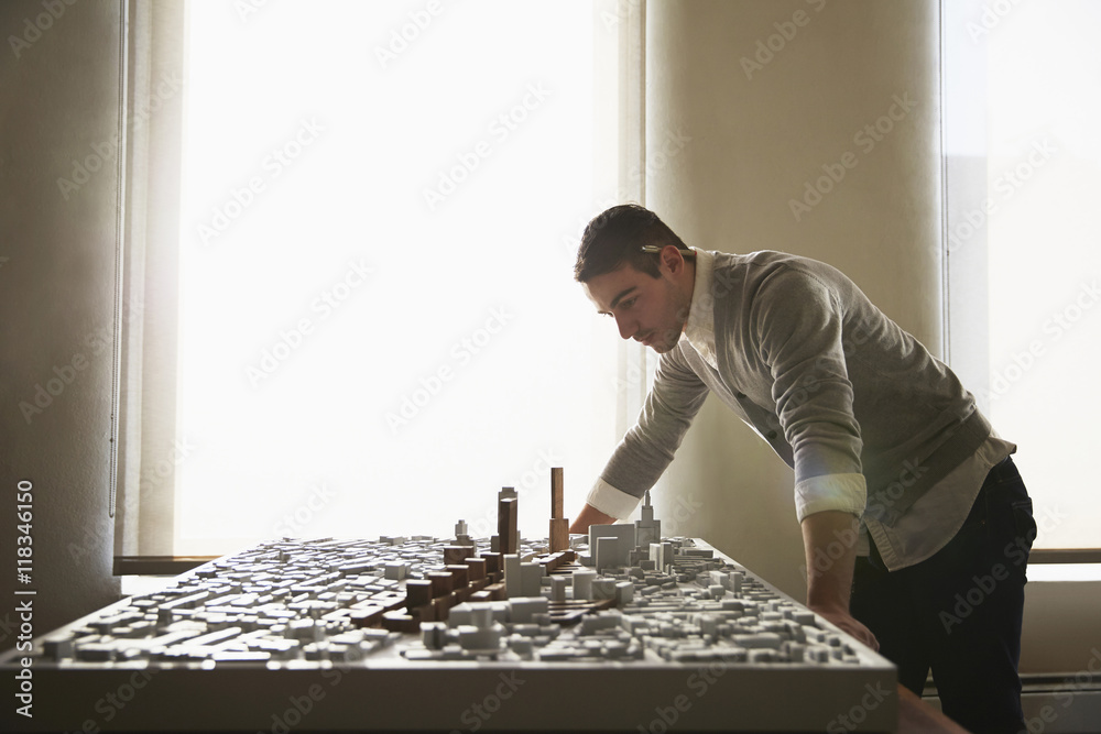 Architect examining urban model in office Architect examining urban model in office