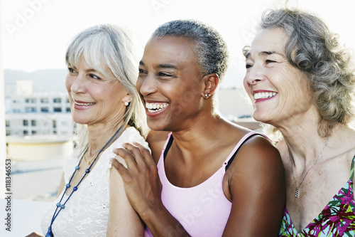 Women smiling together on urban rooftop photo