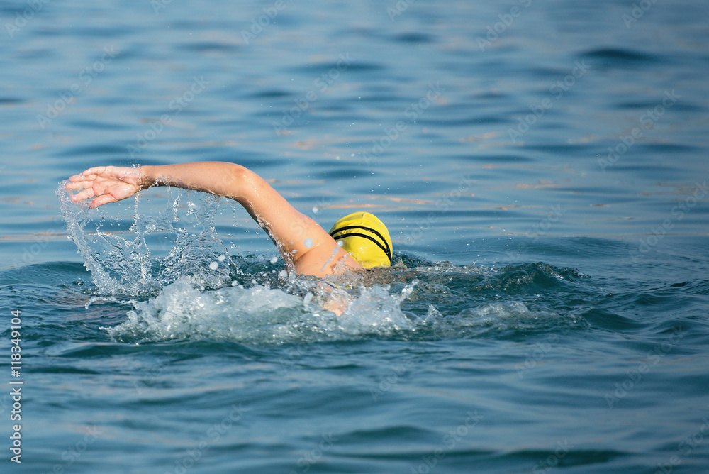 Woman swimmer swimming crawl in blue sea