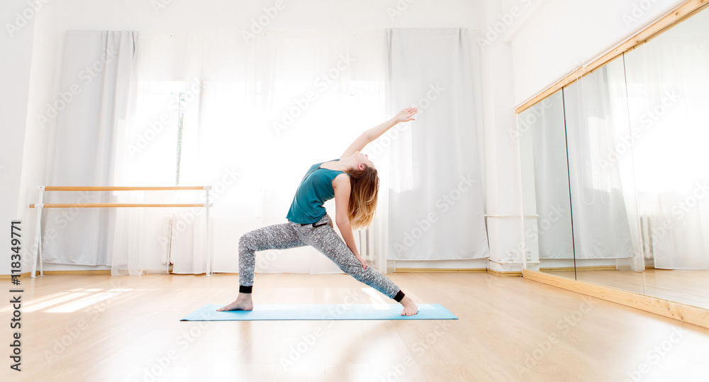 Young beautiful woman doing yoga in bright spacious studio Young beautiful woman doing yoga in bright spacious studio
