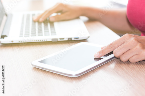 Close Up of Asian woman s hands using mobile phone and Coffee shop Laptop with blank copy space screen for your advertising text message or content  in the morning light.