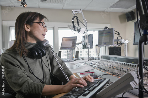 Asian dj working at radio station photo