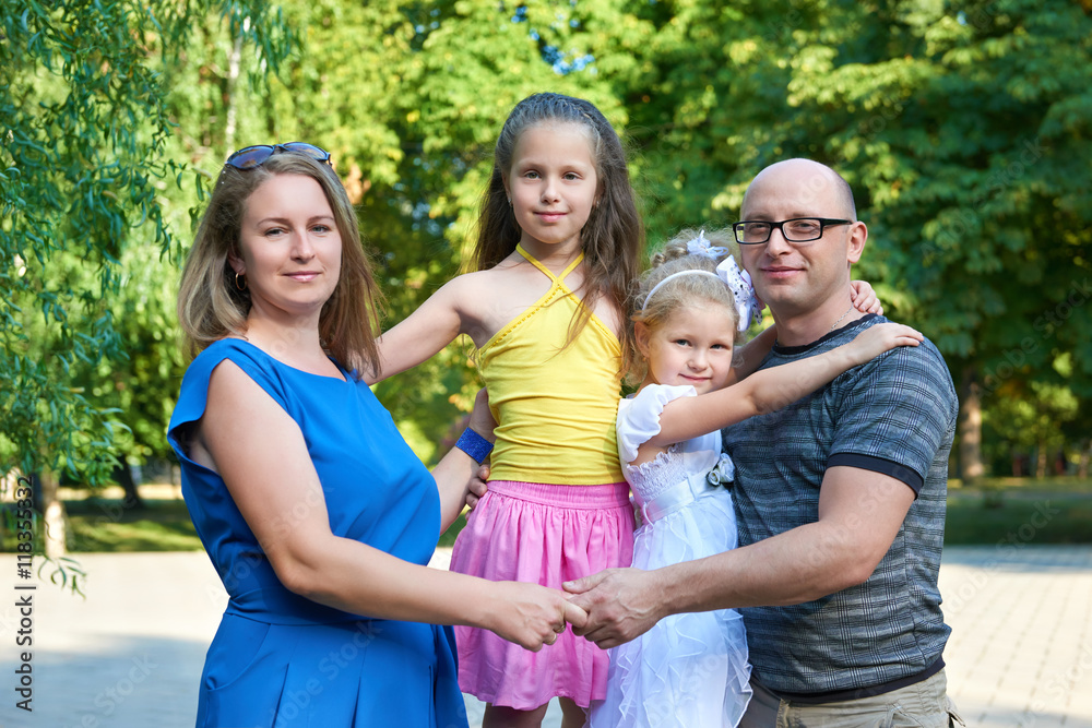 happy family posing on outdoor, group of four people portrait in city park, summer season, child and parent happy family posing on outdoor, group of four people portrait in city park, summer season, child and parent