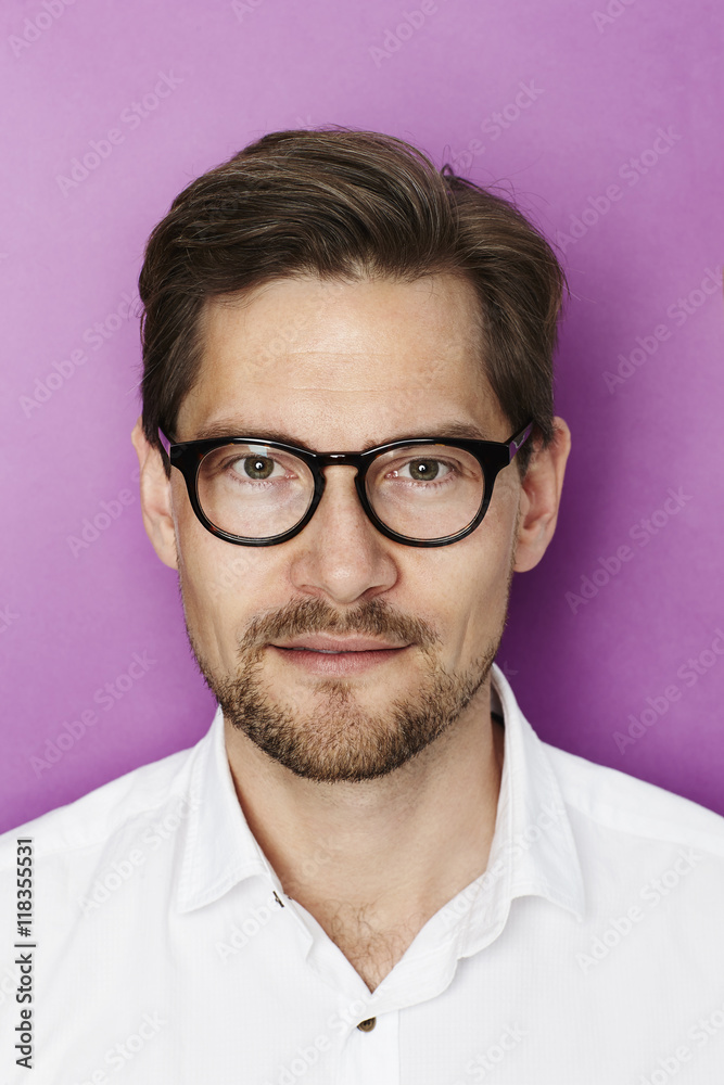 Obraz premium Handsome man in spectacles, portrait against purple