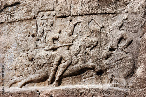 Historical relief carved between 239 - 70 AD about Victory of Bahram II, Sasanian King of Persia. Ancient monuments of Naqsh-e Rustam, rocky necropolis near Persepolis, Iran.  photo