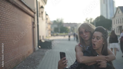 Two girls friends laughing and hugging. hug and smile outdoor