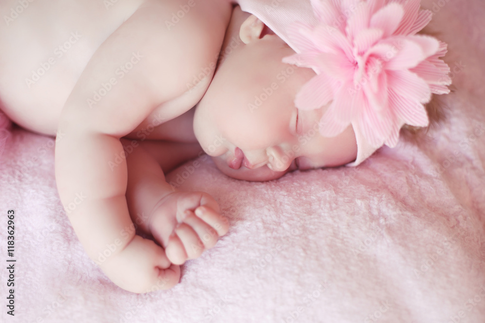 Close-up beautiful sleeping baby girl. Newborn baby girl with fl Close-up beautiful sleeping baby girl. Newborn baby girl with fl