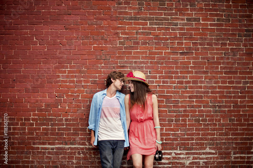 Couple leaning on brick wall photo