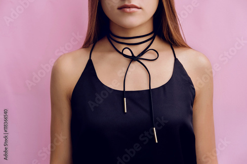 Stylish girl with black choker bow accessory.