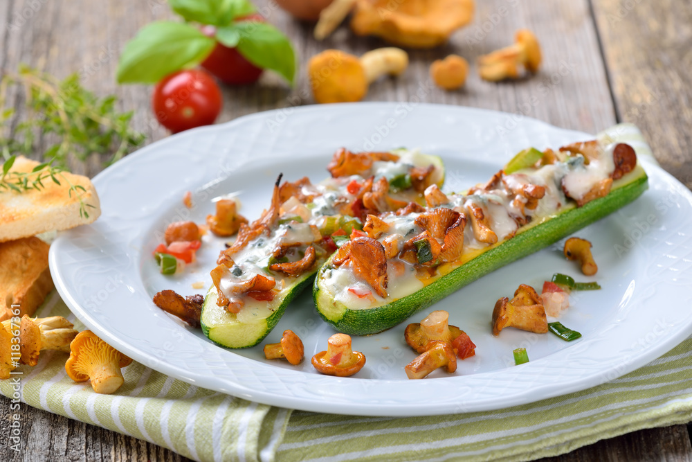 Mit Gorgonzola überbackene Zucchinischiffchen mit frischen Pfifferlingen und saftigem, geschnittenen Gemüse - Zucchini halves stuffed with fresh chanterelles and topped with grated gorgonzola cheese 