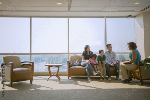 Doctor talking to patients in waiting room photo