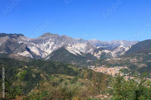 Panoramic view of the Alpi Apuane mountain chain with white marble quarries over Carrara's town in Tuscany, Italy.