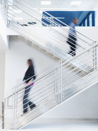 Blurred view of business people climbing office staircase