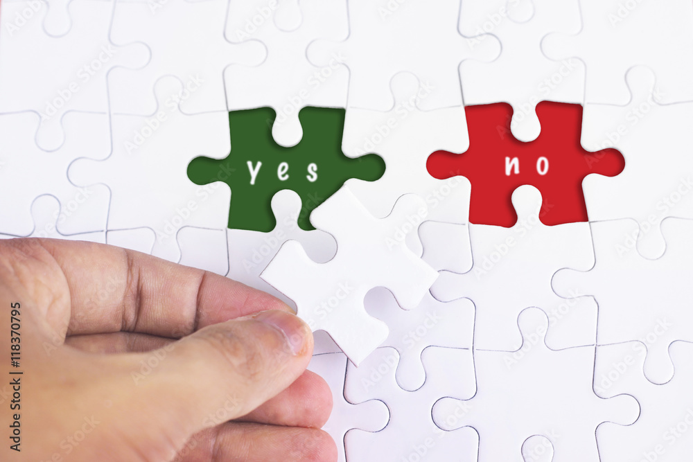 Business Concept - Female hand and missing puzzle with YES and NO WORD Business Concept - Female hand and missing puzzle with YES and NO WORD