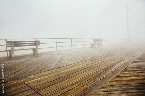 Fog over benches on wooden boardwalk