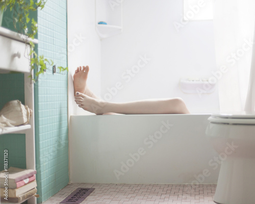 Legs of Caucasian woman relaxing in bath photo