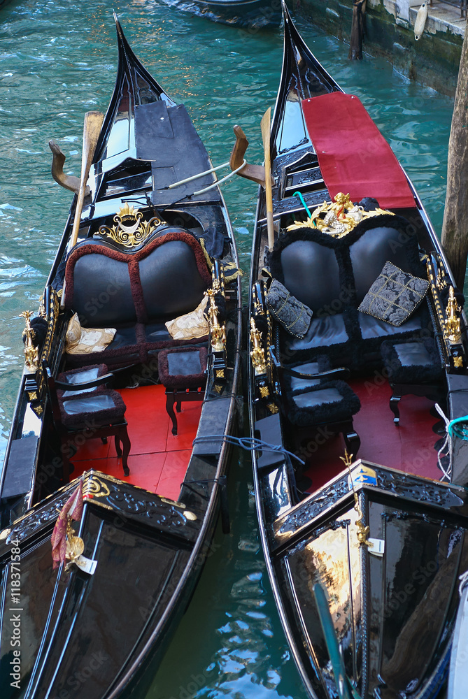 Two moored gondolas  on the pier on the canal in Venice, Italy