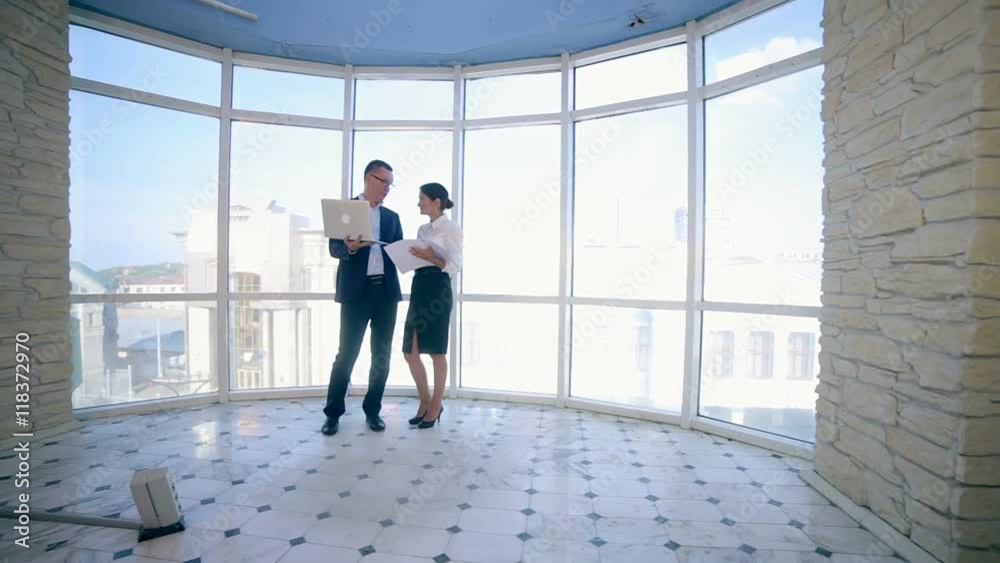Businessmen man and woman discuss work project in a modern office building near clean panoramic window. Business concept. Steadicam shoot. HD. Businessmen man and woman discuss work project in a modern office building near clean panoramic window. Business concept. Steadicam shoot. HD.