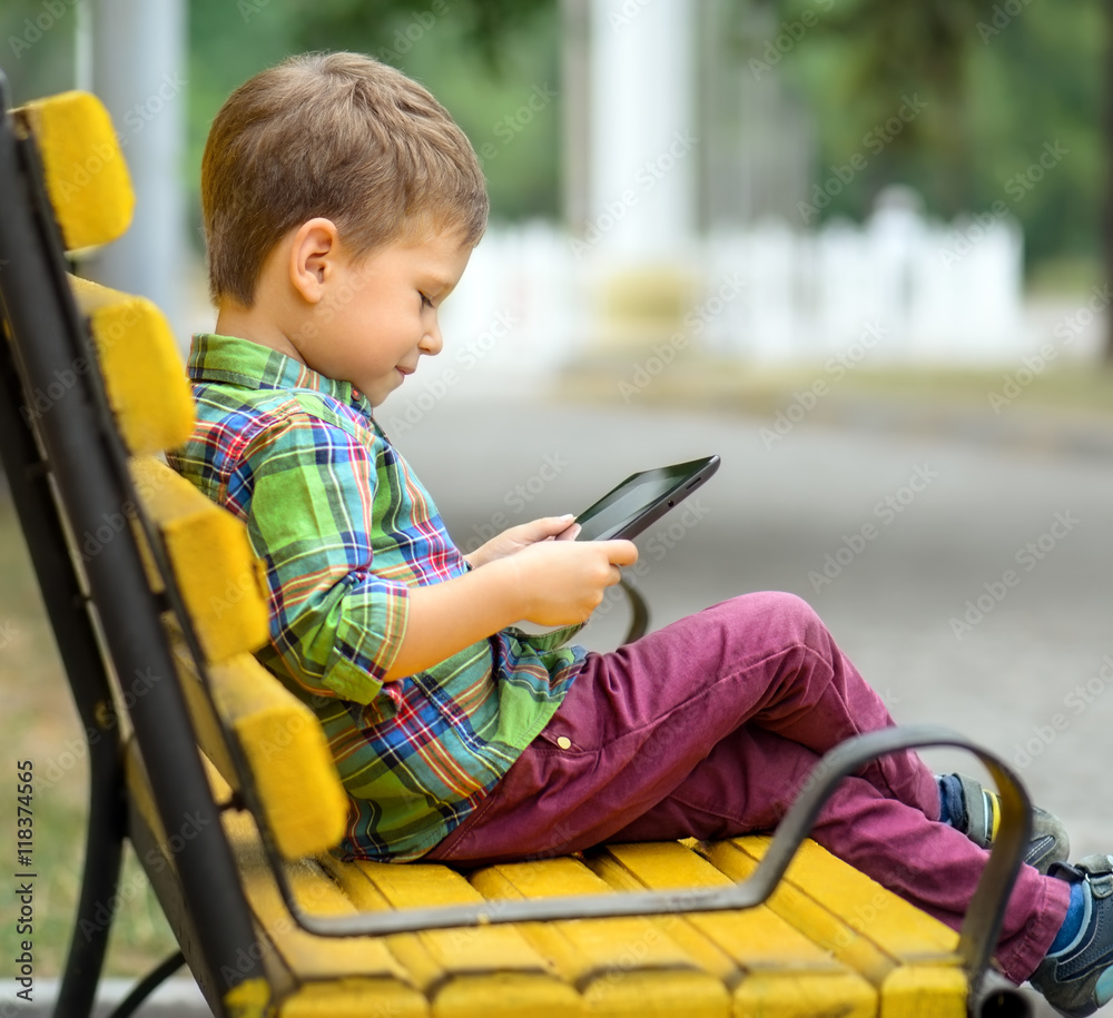 Boy with tablet computer in park Boy with tablet computer in park