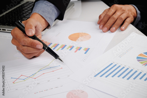 Business man hand pointing at business document during discussion at meeting