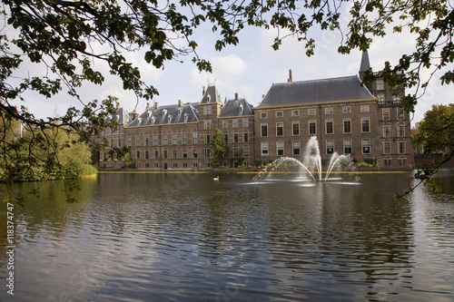 Dutch building and fountain on pond photo