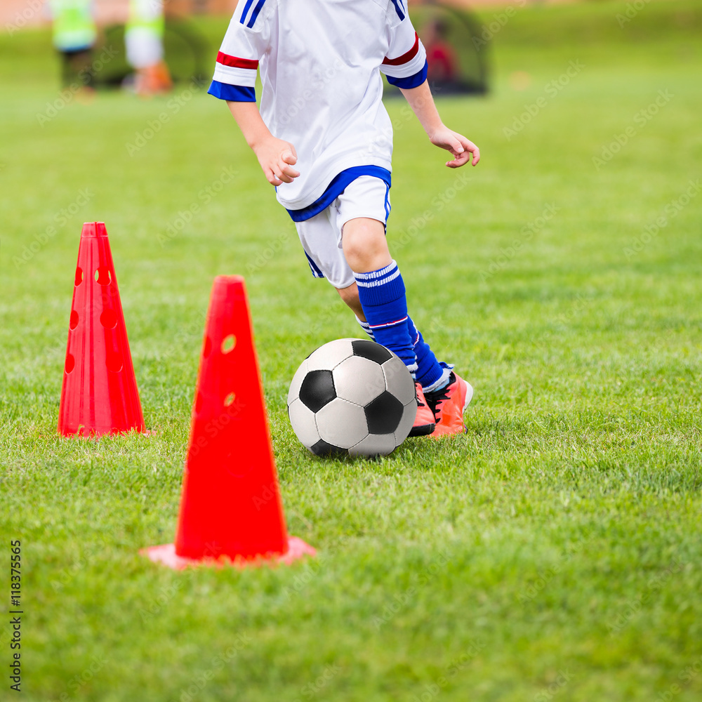 Kid playing soccer. Training football session for children