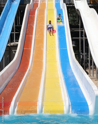 A father and son having fun on a water slide in a waterpark while on vacation in turkey, 2016