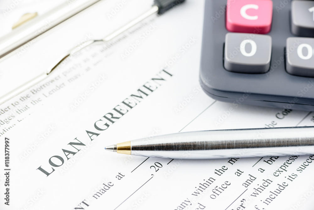 Φωτογραφία Blue ballpoint pen and a calculator on a loan agreement, preparation for filling and signing a form on a clipboard