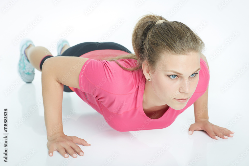 Portrait of a sports woman doing push ups isolated on a white background. Portrait of a sports woman doing push ups isolated on a white background.
