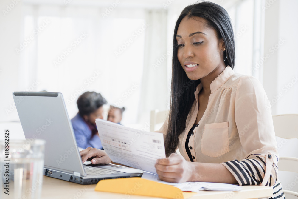 Black woman paying bills using laptop Black woman paying bills using laptop