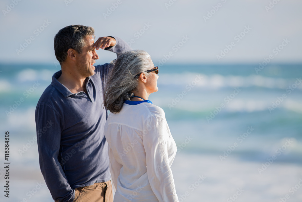 mid aged couple laying out on the beach