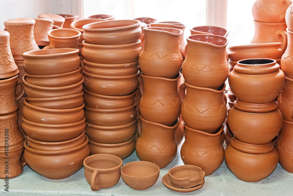 Pottery ceramic handmade stacked in tiers on window. Pottery ceramic handmade stacked in tiers on window.