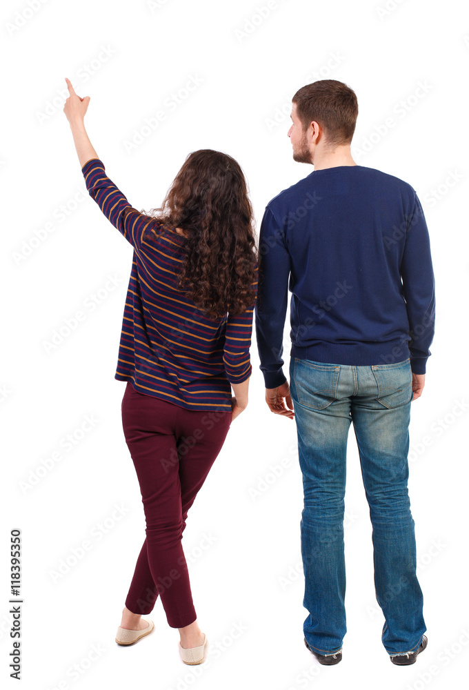 young couple pointing at wal Back view (woman and man). Rear view people  collection. backside view of person. Isolated over white background.  Swarthy girl and a bearded man looking up. Stock Photo |