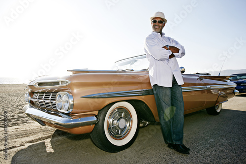 Black man leaning on convertible